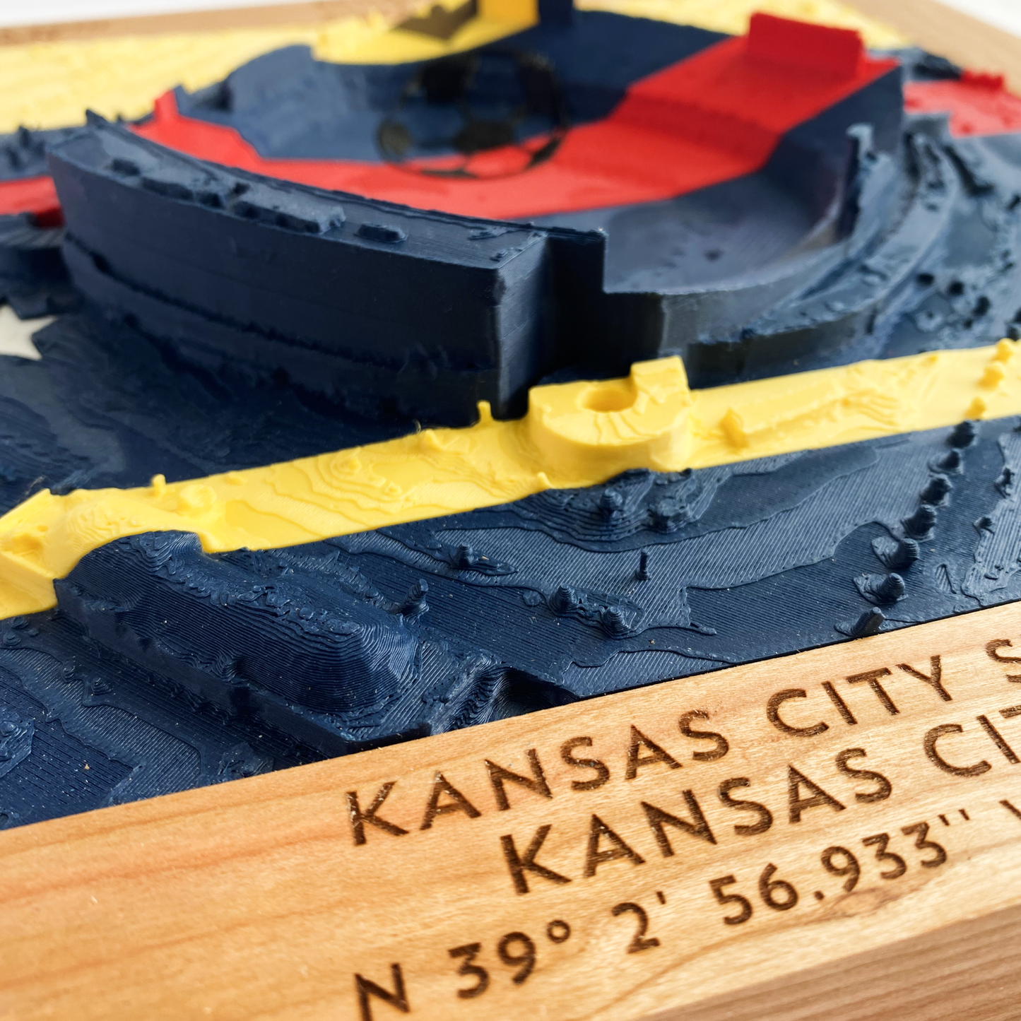 3D printed model of Arrowhead Stadium imprinted with Ecuador's flag on the top half and Curacao's flag on the bottom half - encased in a solid wooden frame engraved with the text "June 20th 2026; Ecuador v Curacao; Group E; Kansas City Stadium, Kansas City, MO, and coordinates"