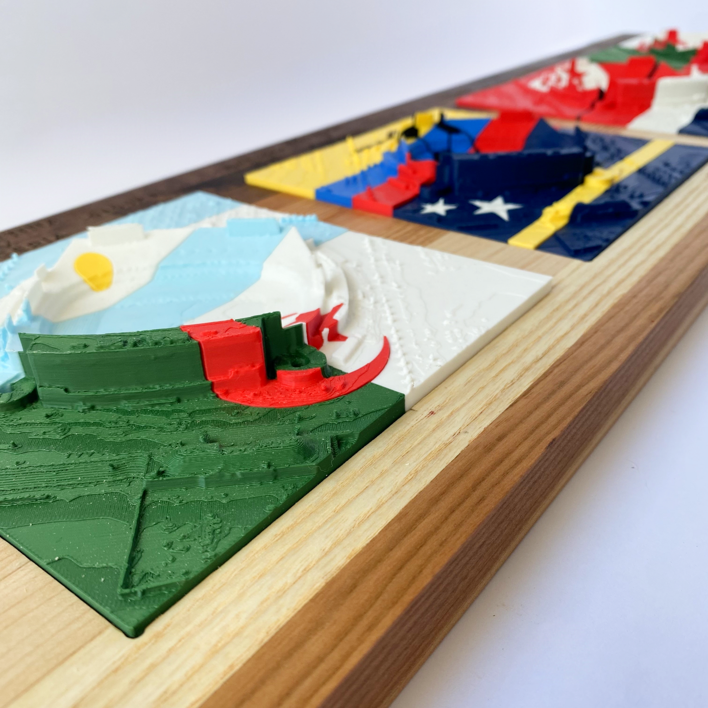 Decorative wall art with embossed flags on a wooden board.