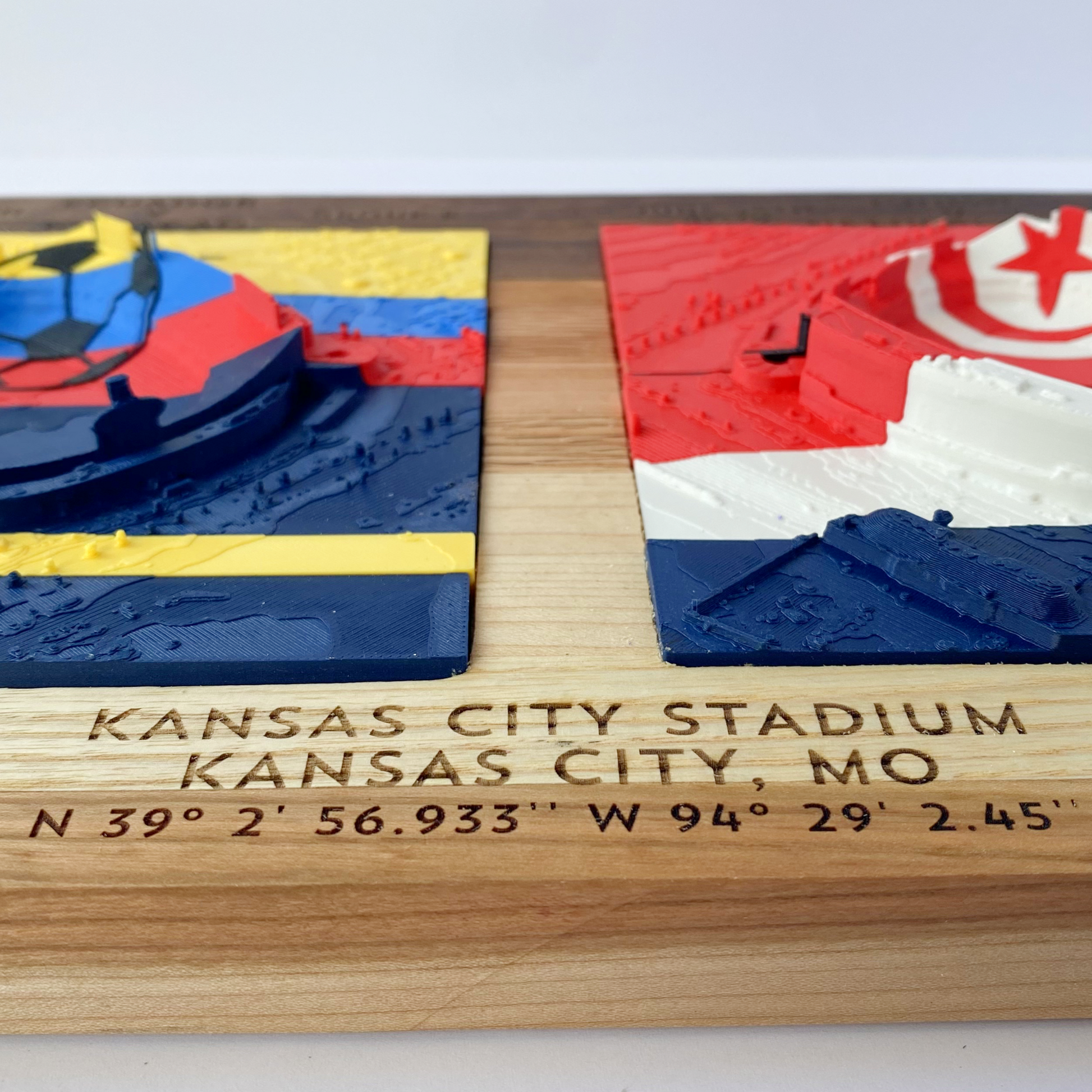 Wooden plaque with 3D map of Kansas City Stadium, featuring a wooden base and colorful top section.