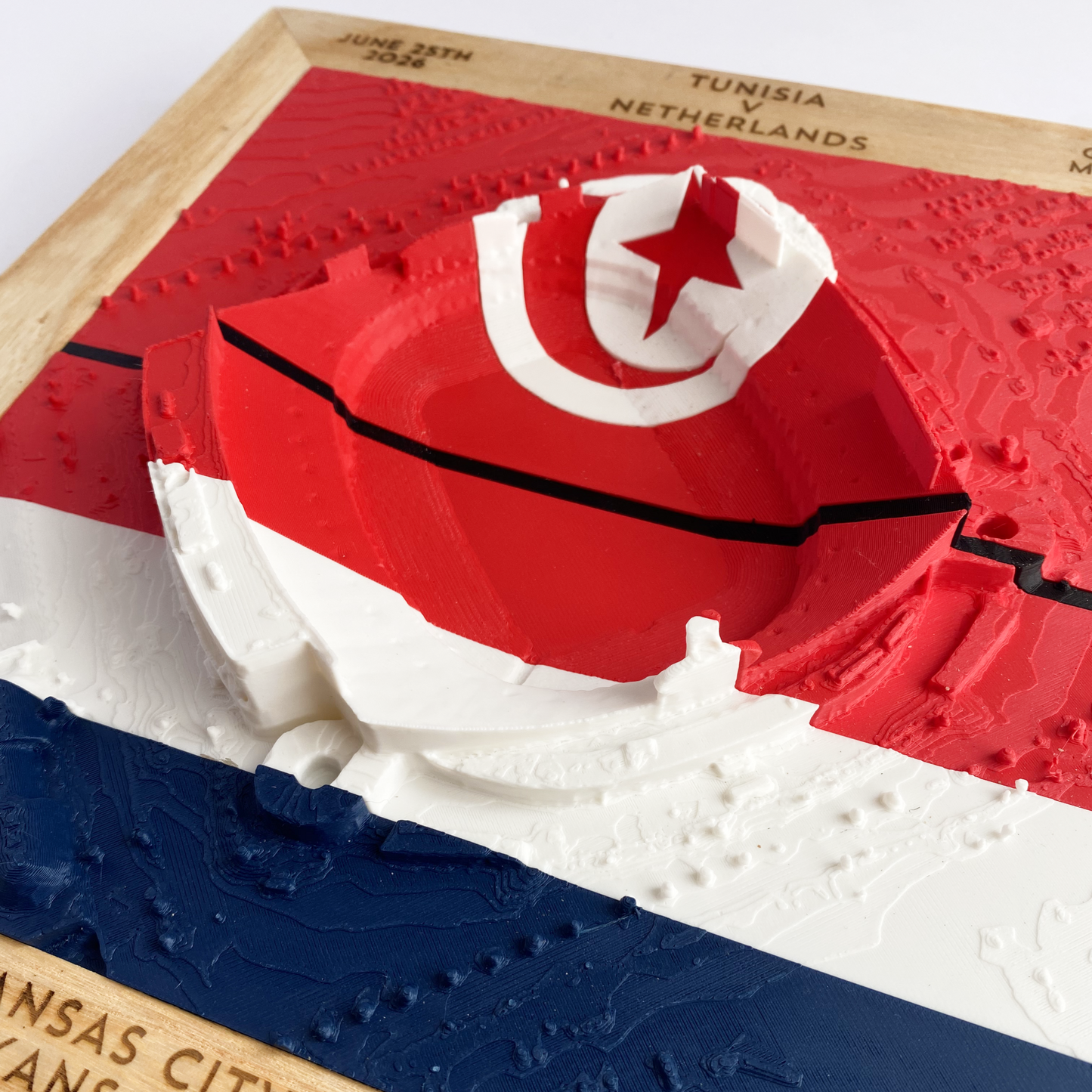 3D printed model of Arrowhead Stadium imprinted with Tunisia's flag on the top half and The Netherland's flag on the bottom half - encased in a solid wooden frame engraved with the text "June 25th 2026; Tunisia v Netherlands; Group F Match 56; Kansas City Stadium, Kansas City, MO, and coordinates"